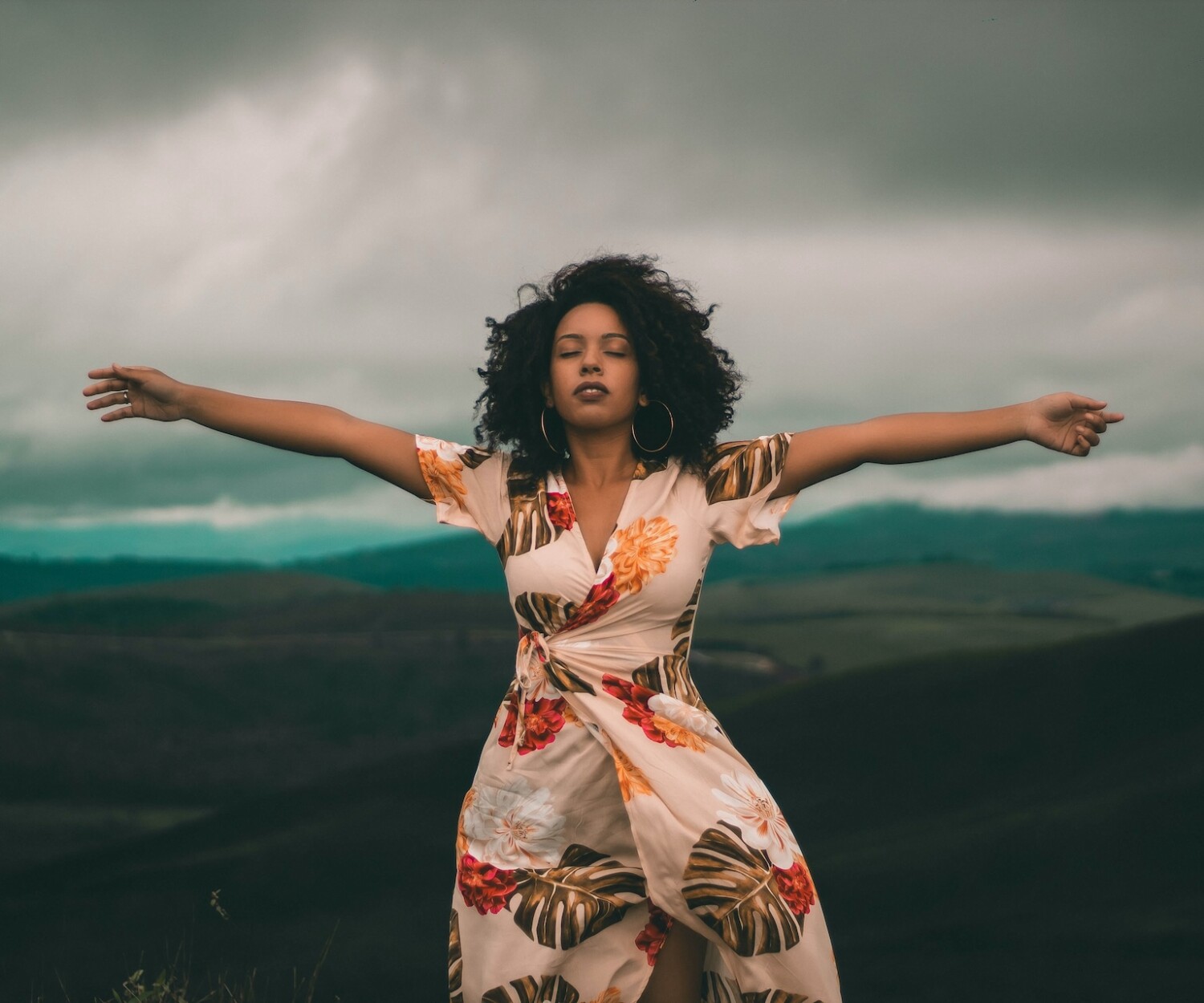 Black woman stands on top of mountain