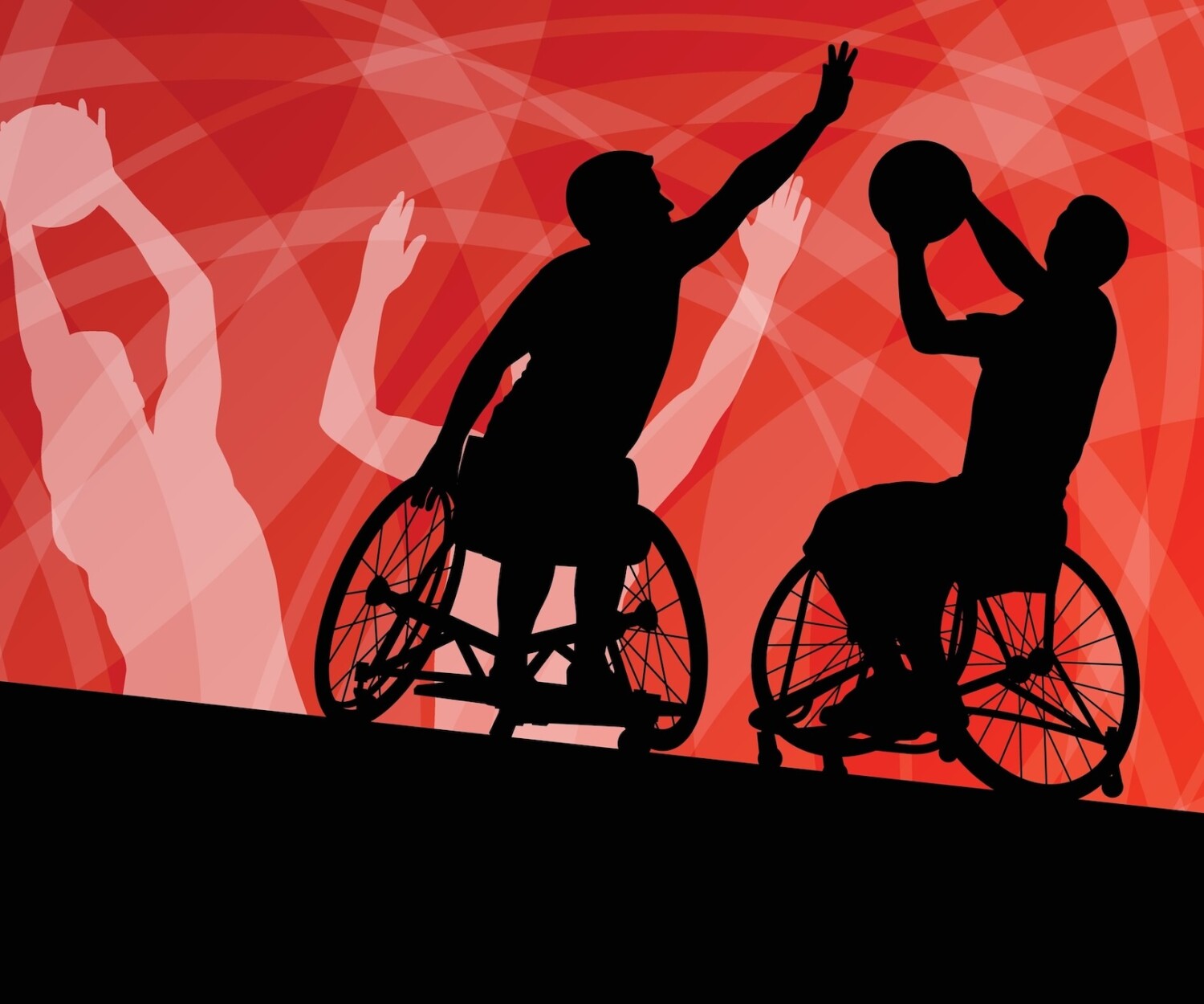 Two people play basketball in wheelchairs